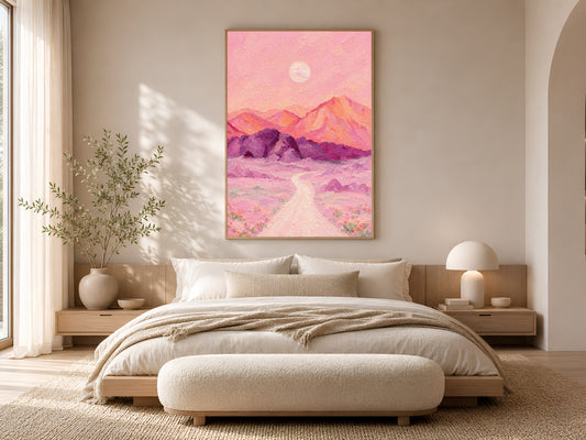 Surreal desert moon print framed above a bed in a warm neutral bedroom.
