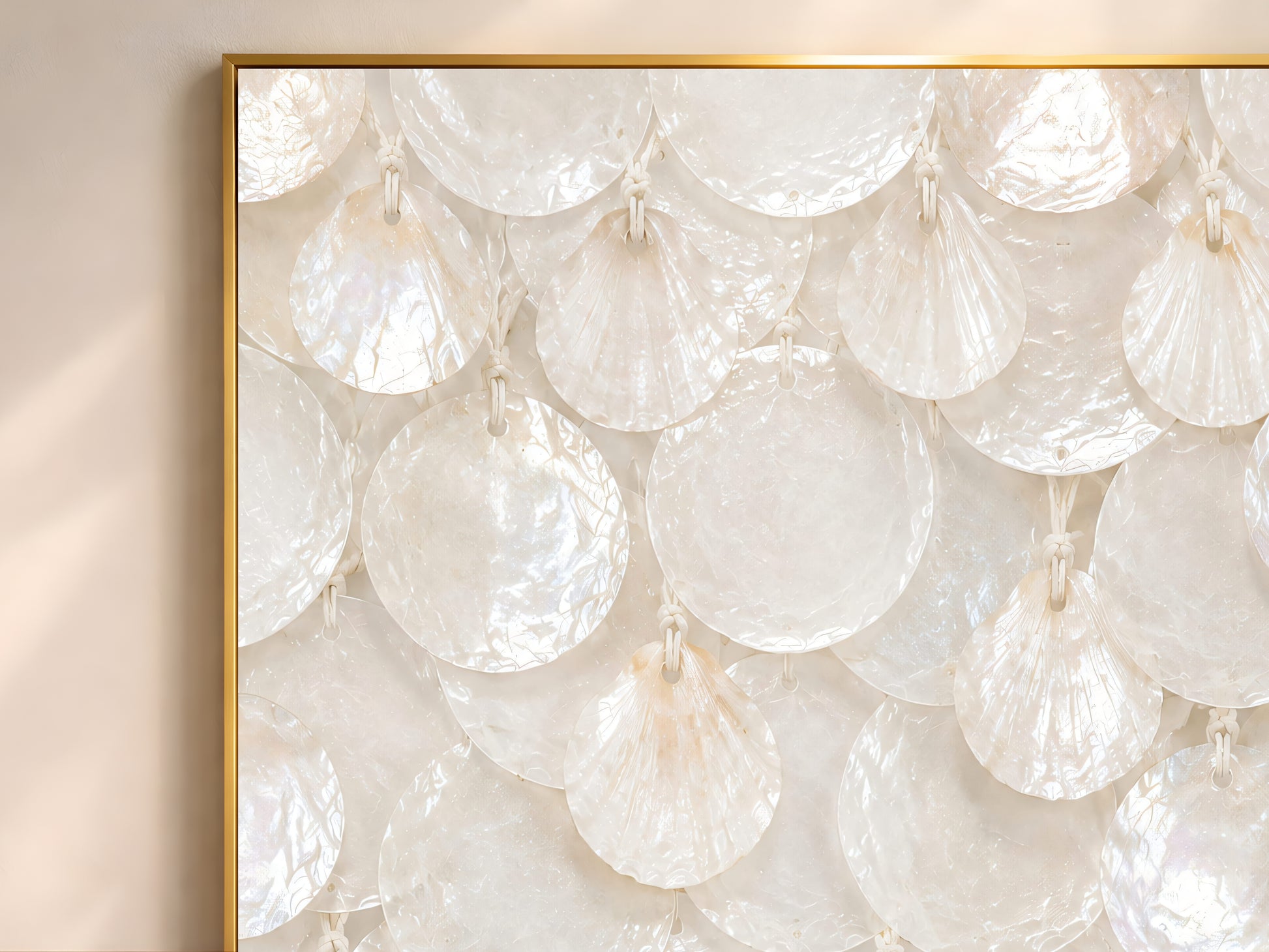Close-up of white capiz shell print showing ivory and cream scalloped shell texture in a gold frame