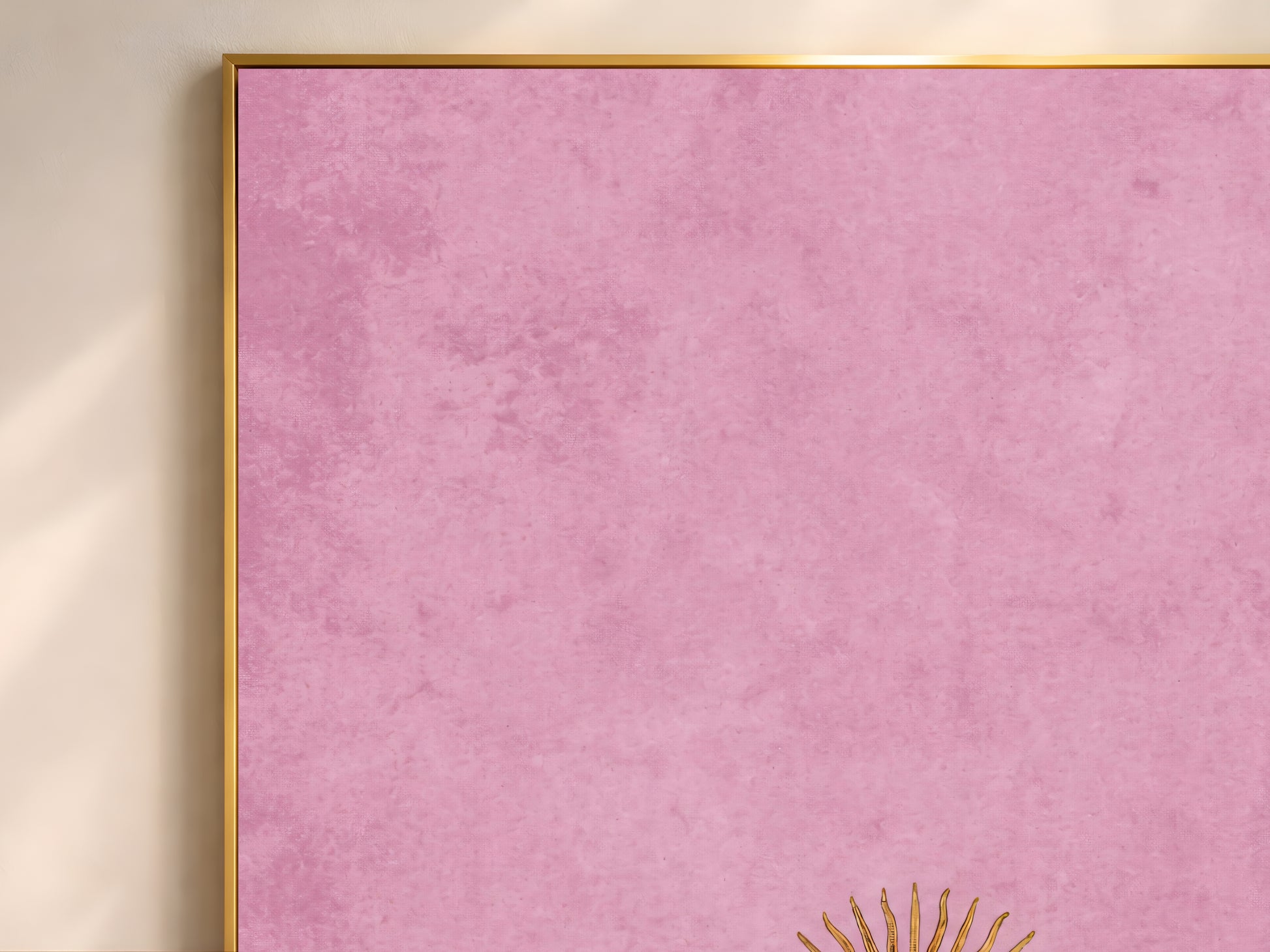Close-up of vintage sun face wall art in a thin gold frame, minimalist celestial print on dusty pink plaster texture