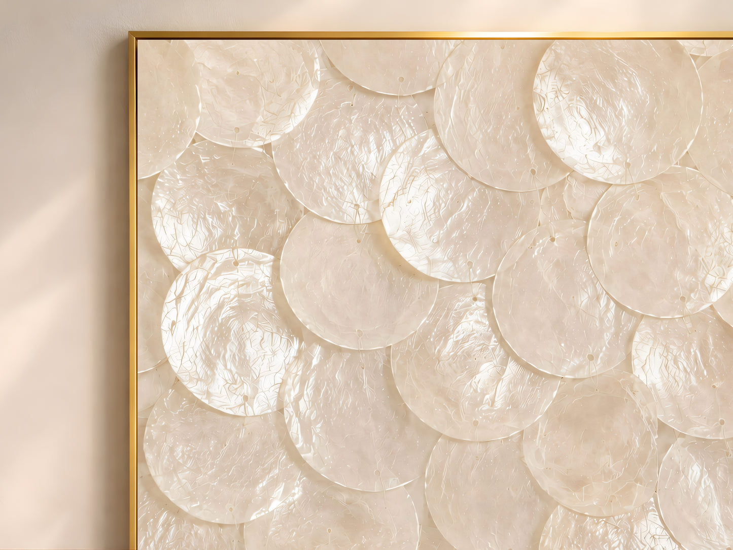 Close-up texture detail of white and oyster pearl capiz shell mosaic wall art, showing layered shimmering shell discs
