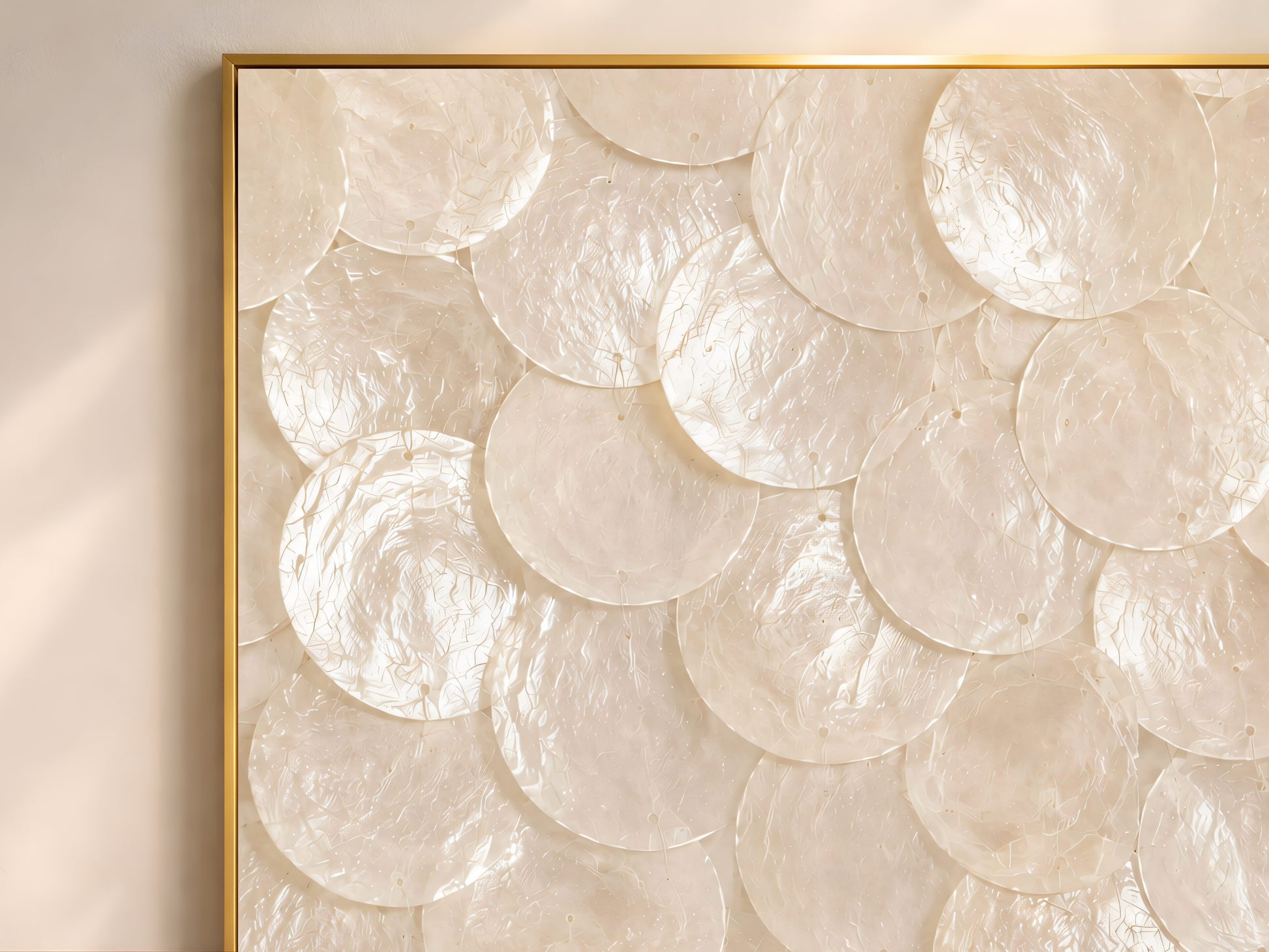 Close-up texture detail of white and oyster pearl capiz shell mosaic wall art, showing layered shimmering shell discs
