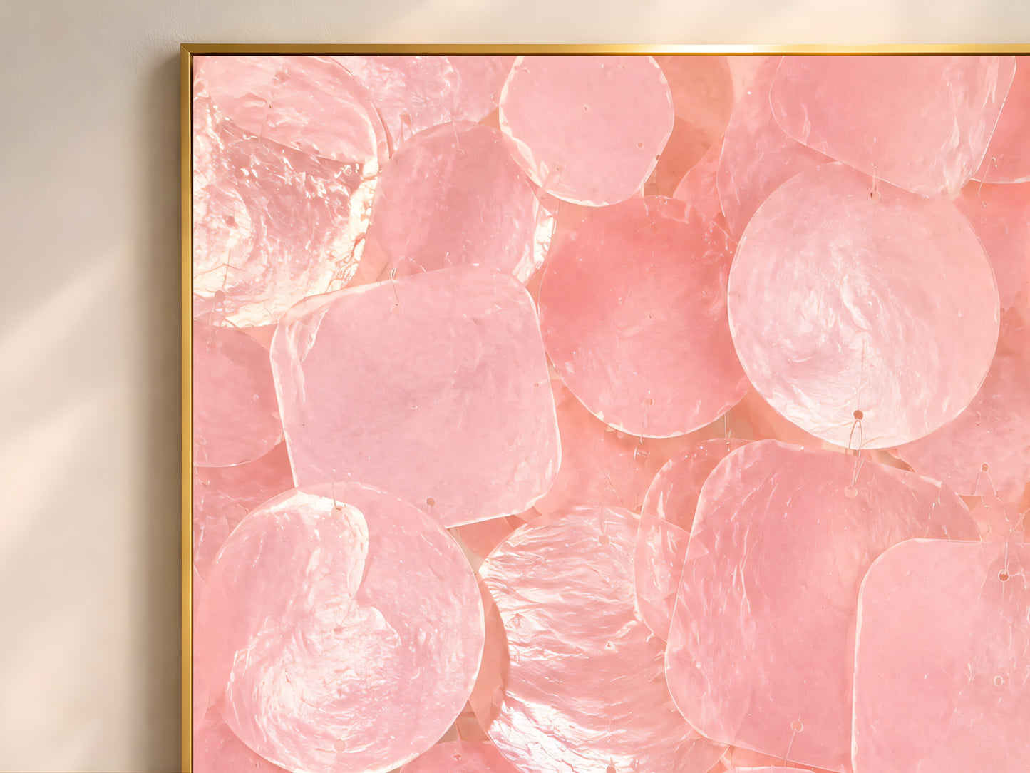 Close-up of pink capiz shell mosaic artwork showing iridescent shell texture and layered shapes.

