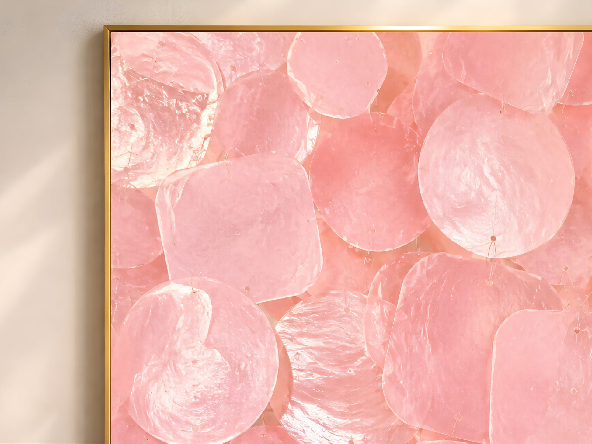 Close-up of pink capiz shell mosaic artwork showing iridescent shell texture and layered shapes.

