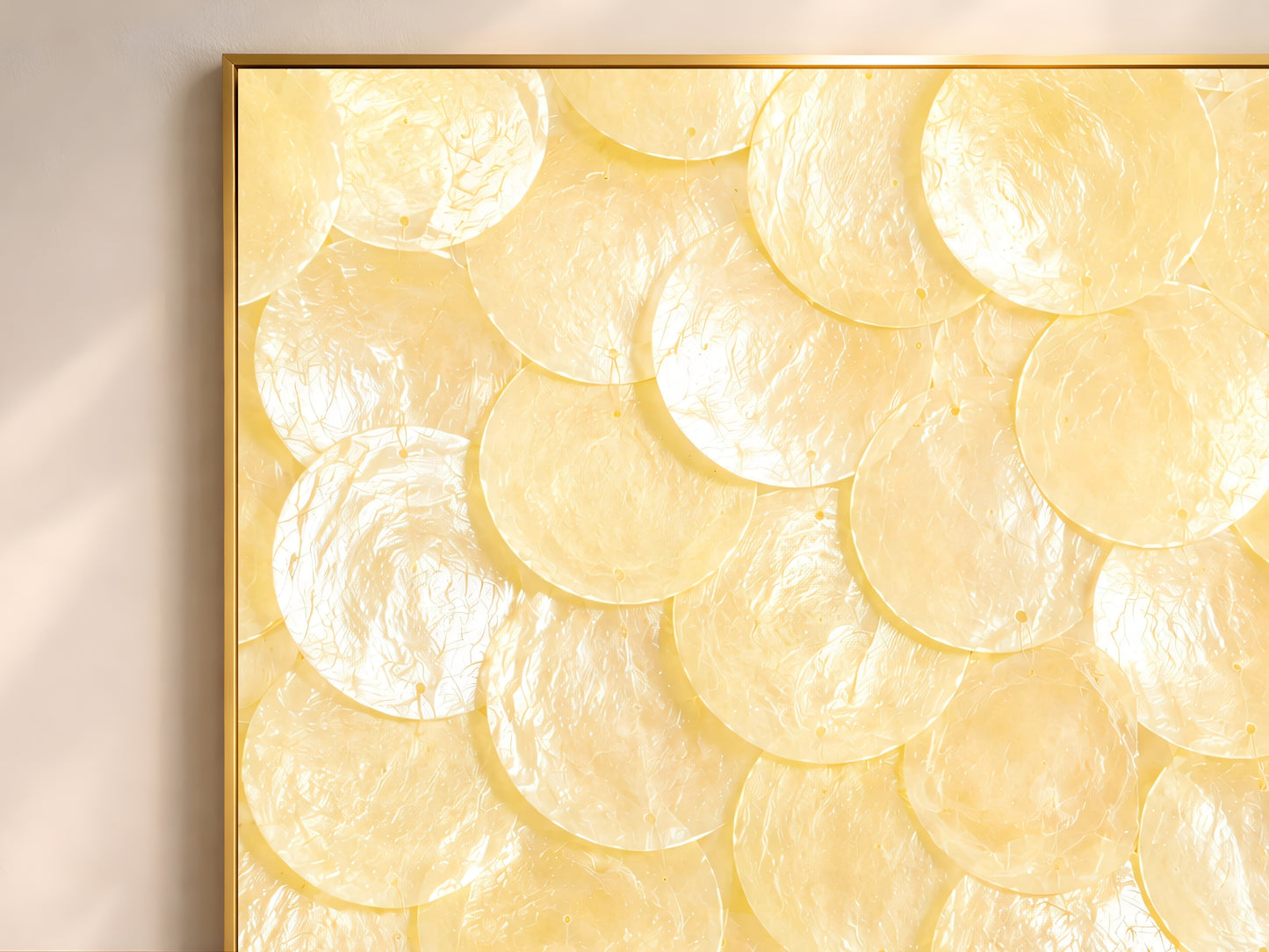 Close-up texture detail of butter yellow and ivory capiz shell mosaic wall art, showing layered shimmering shell discs
