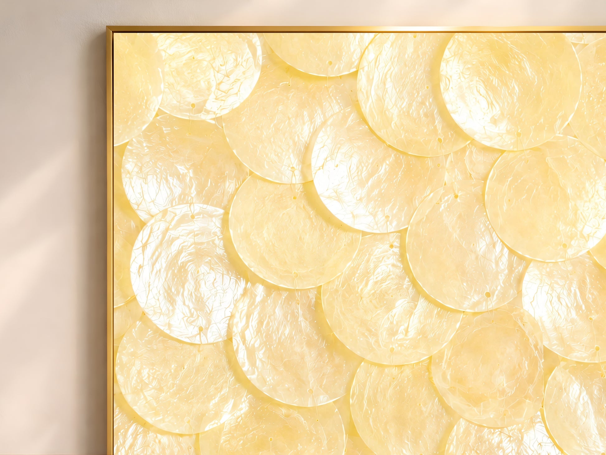 Close-up texture detail of butter yellow and ivory capiz shell mosaic wall art, showing layered shimmering shell discs

