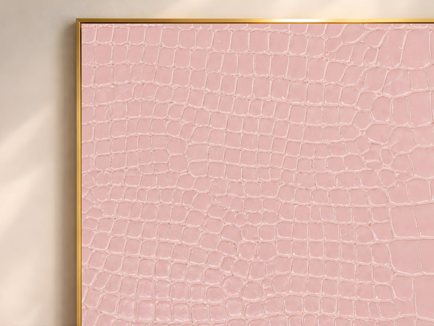 Close-up of pink crocodile leather texture print showing its scaled, tactile pattern.
