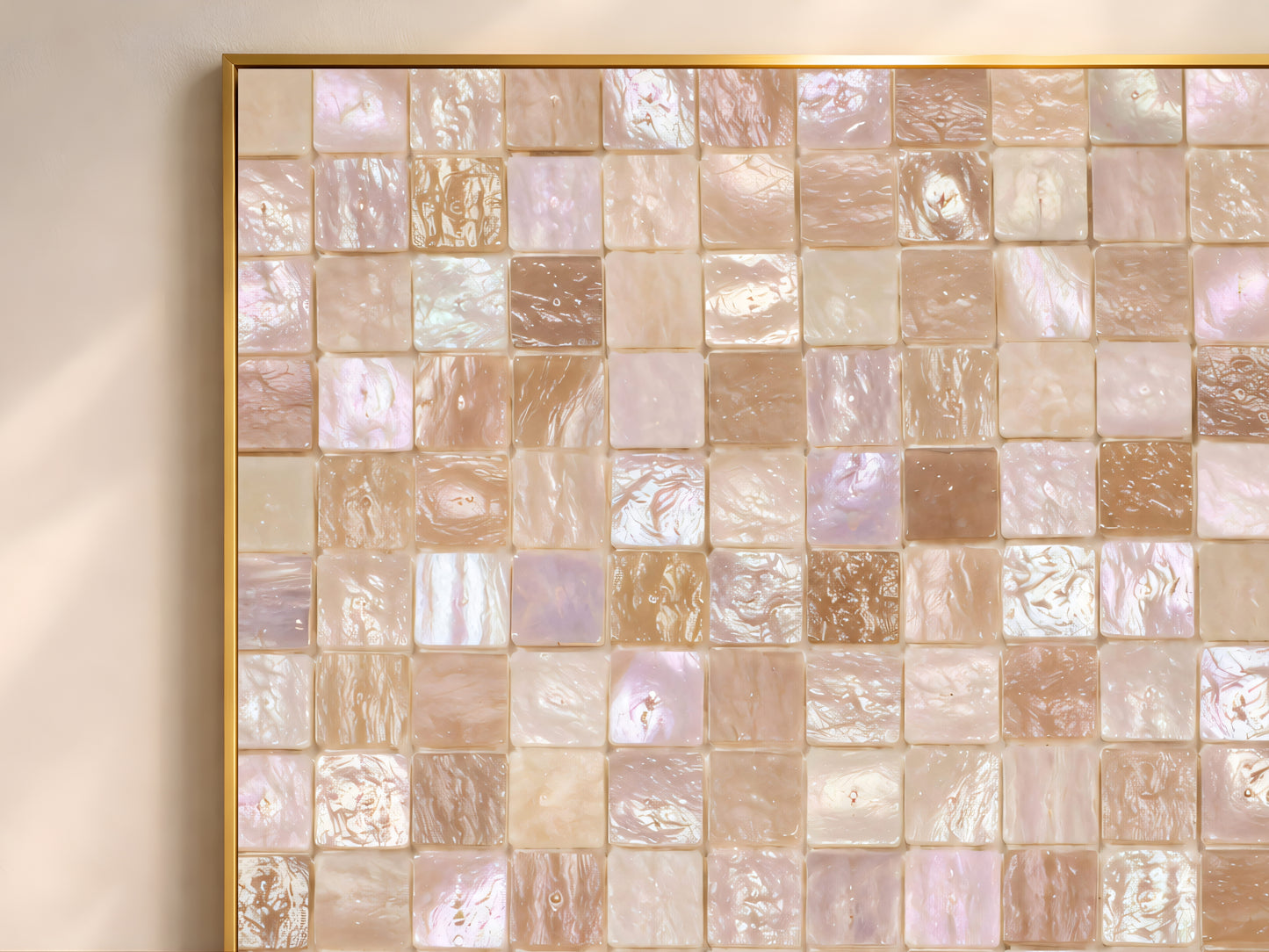 Close-up of mother of pearl mosaic tile print showing warm amber, blush, and pearl-white squares.
