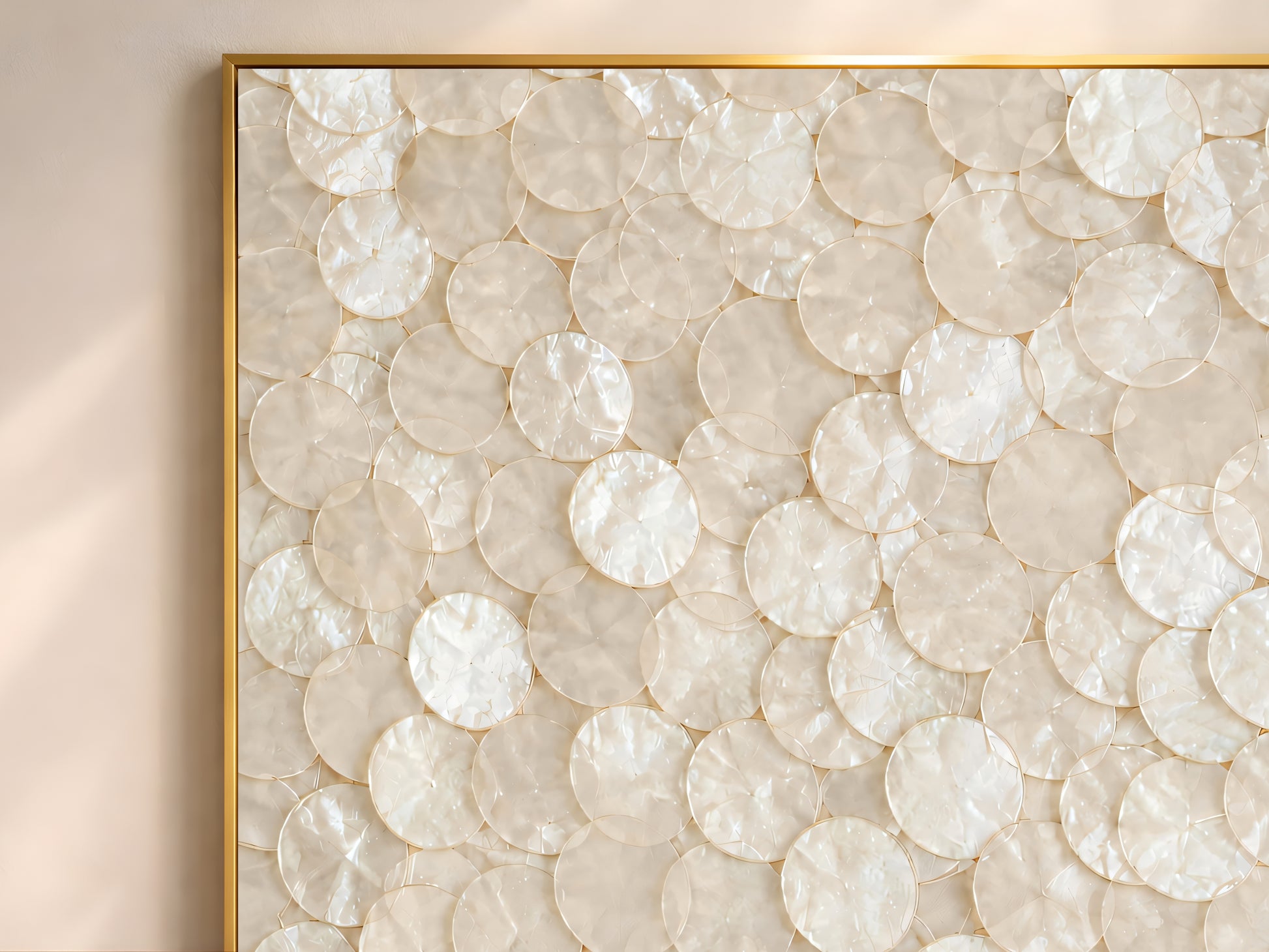 Close-up of capiz shell wall art print showing layered cream and champagne mother of pearl disc texture
