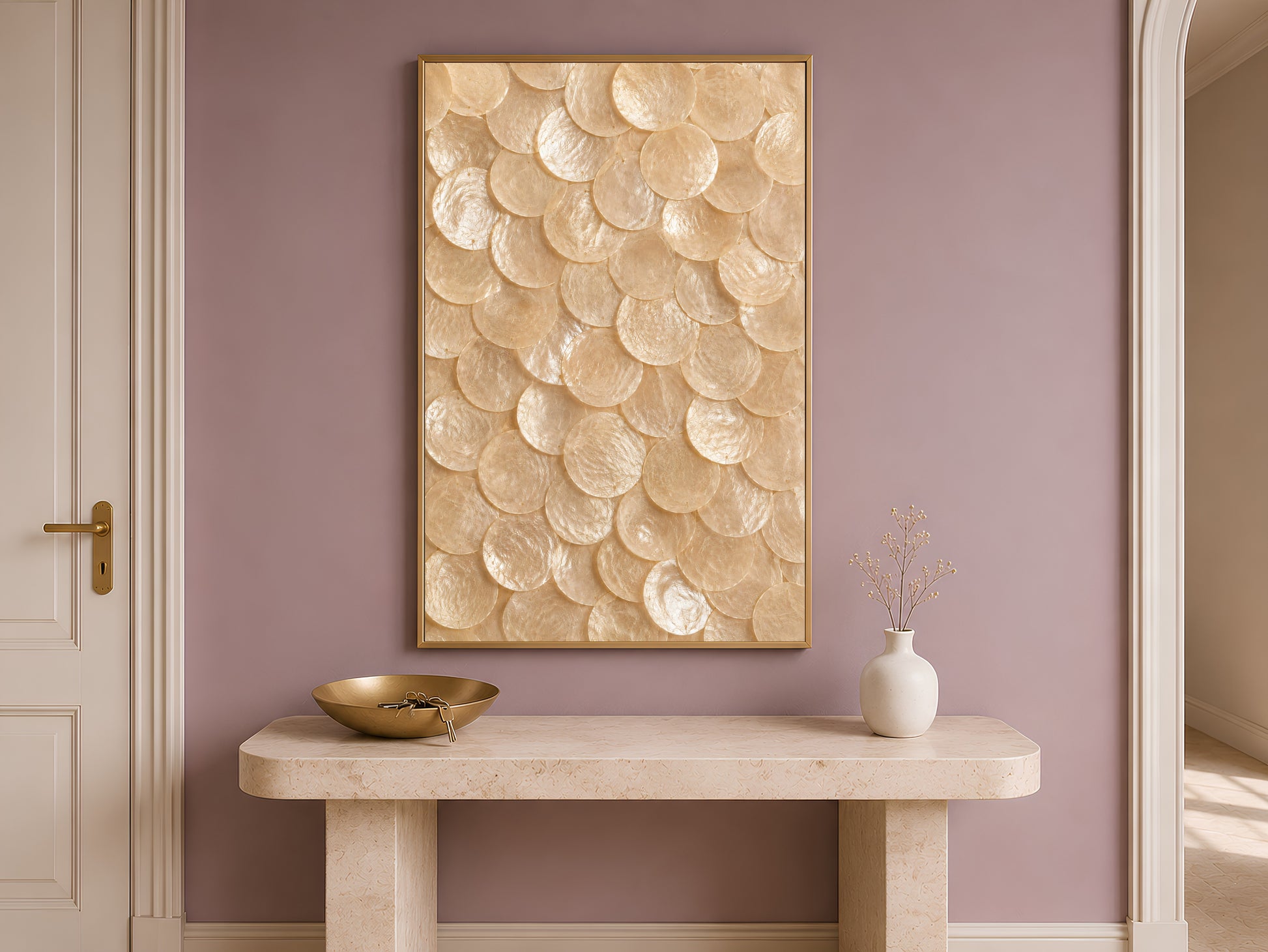 Natural capiz shell wall art in a gold frame hung above a console table in a warm-toned entryway.