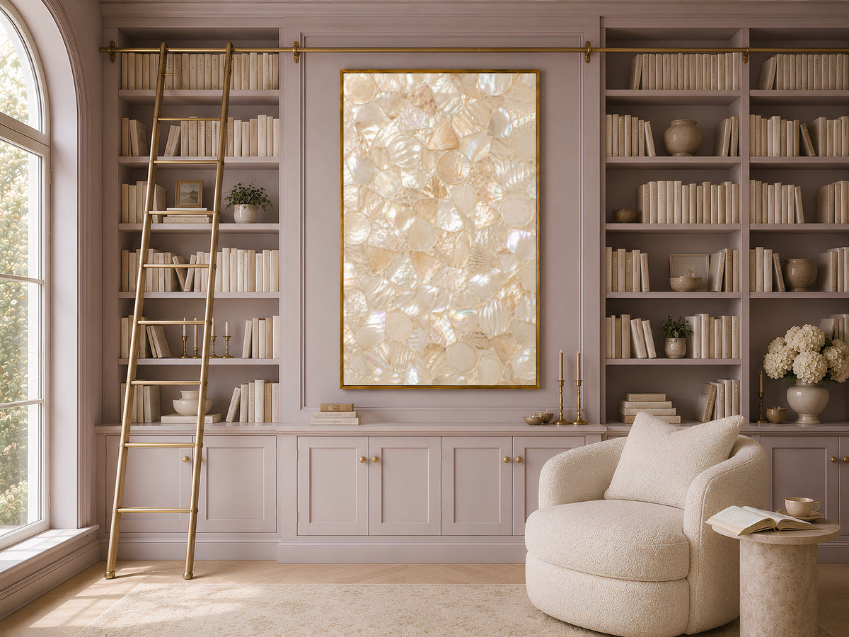 Mother of pearl wall art framed on a bookshelf wall with an armchair and soft neutral decor