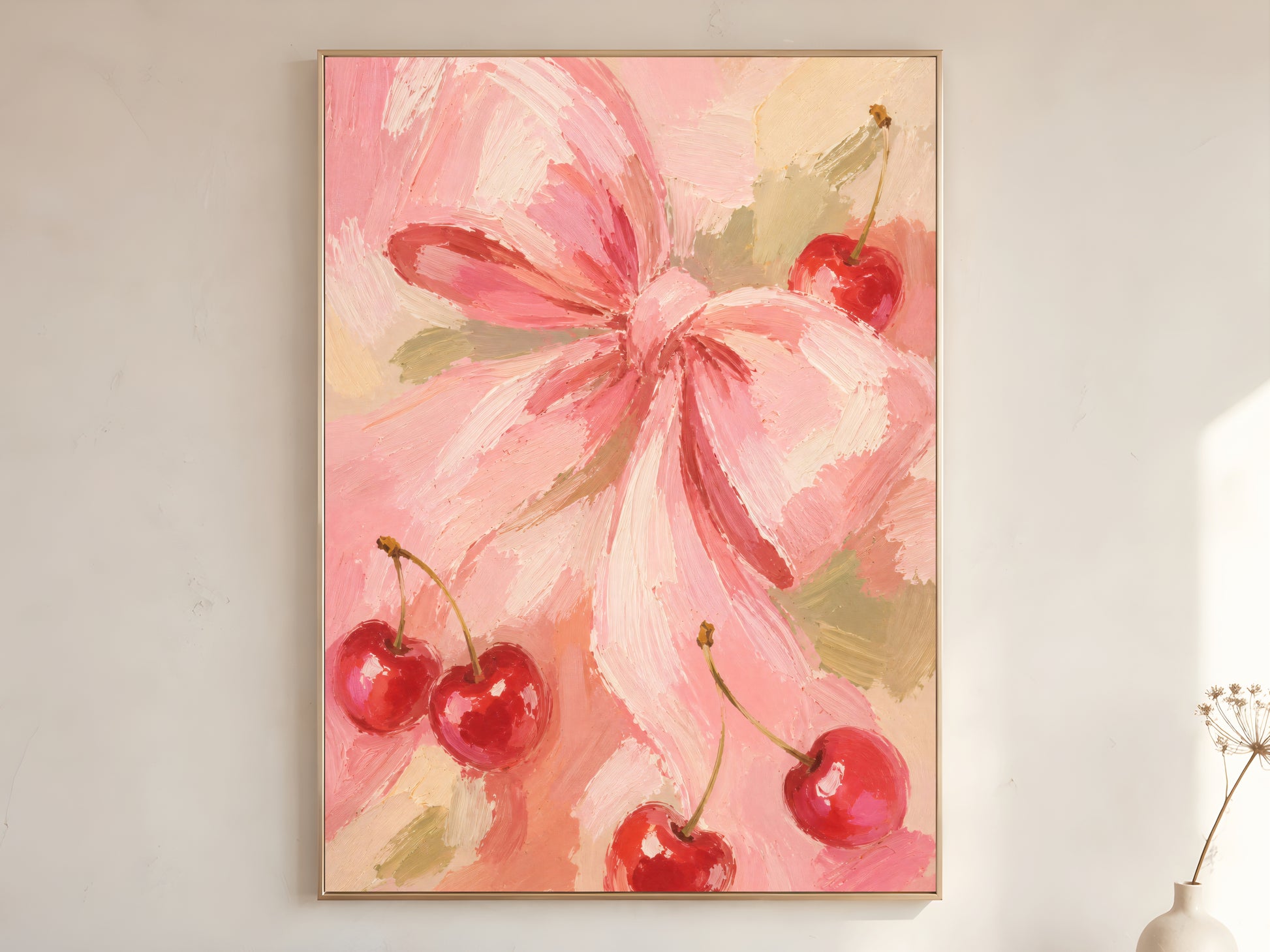 Pink cherry bow oil painting wall art in gold frame leaning against a white wall with dried florals