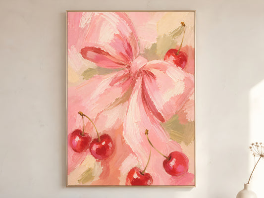 Pink cherry bow oil painting wall art in gold frame leaning against a white wall with dried florals