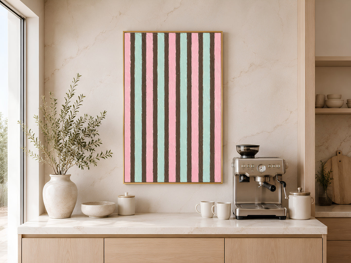 Pink mint stripe wall art in gold frame above kitchen sideboard with coffee machine and neutral vases

