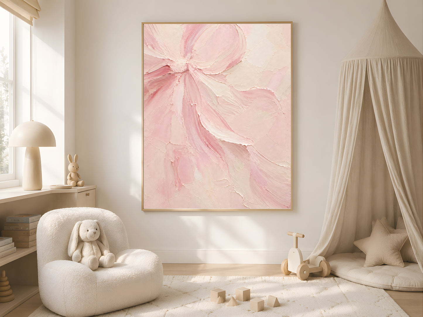 Blush pink coquette bow wall art print framed above a canopy daybed in a girl's nursery