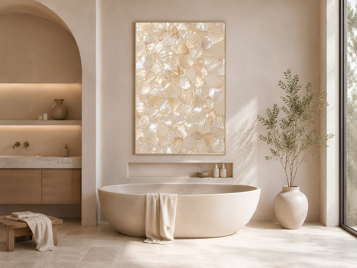 Framed neutral shell mosaic wall art in a sunlit spa bathroom with a freestanding soaking tub