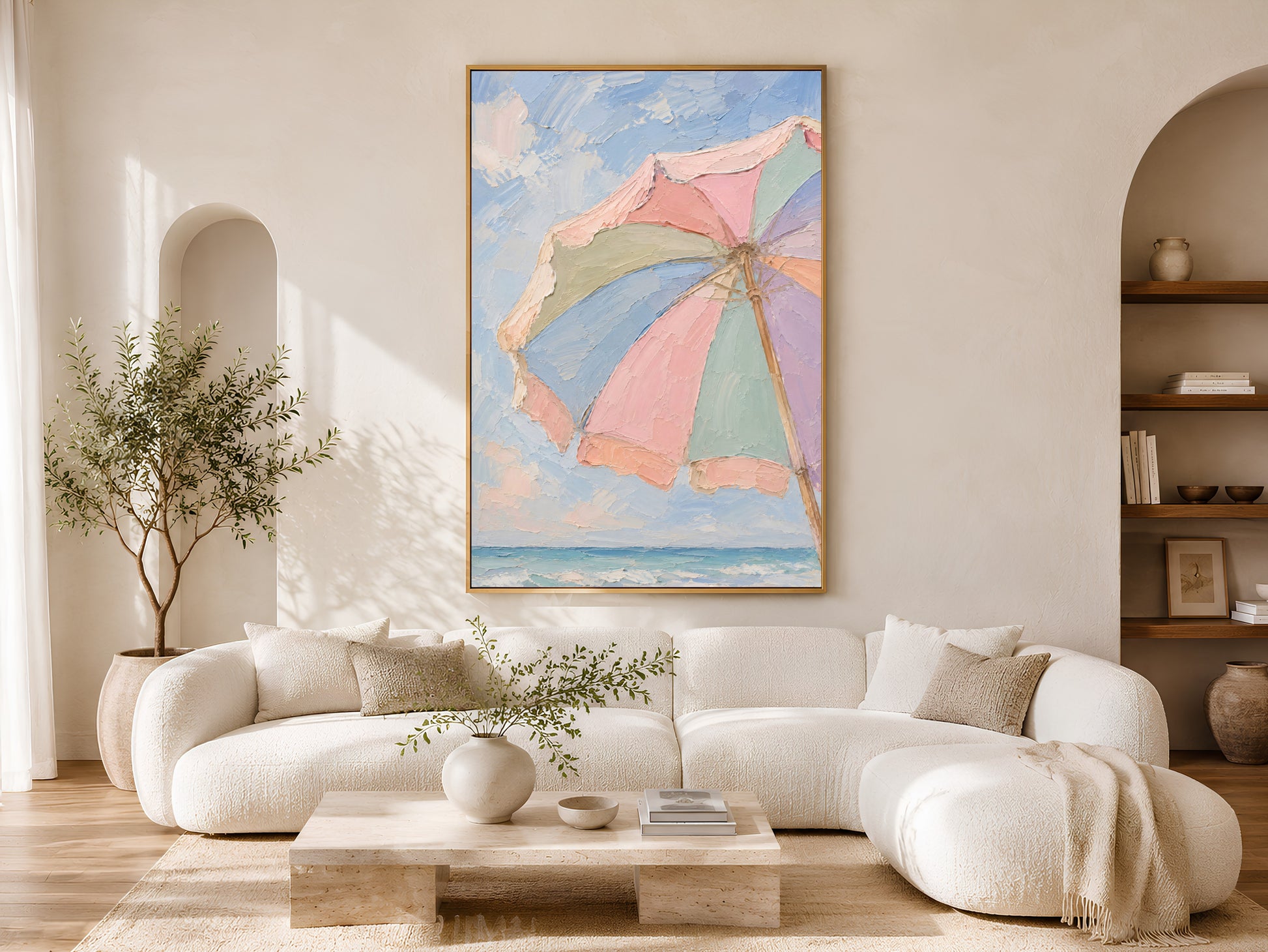 Pastel beach umbrella print framed in gold above cream sofa in bright living room with arched shelving

