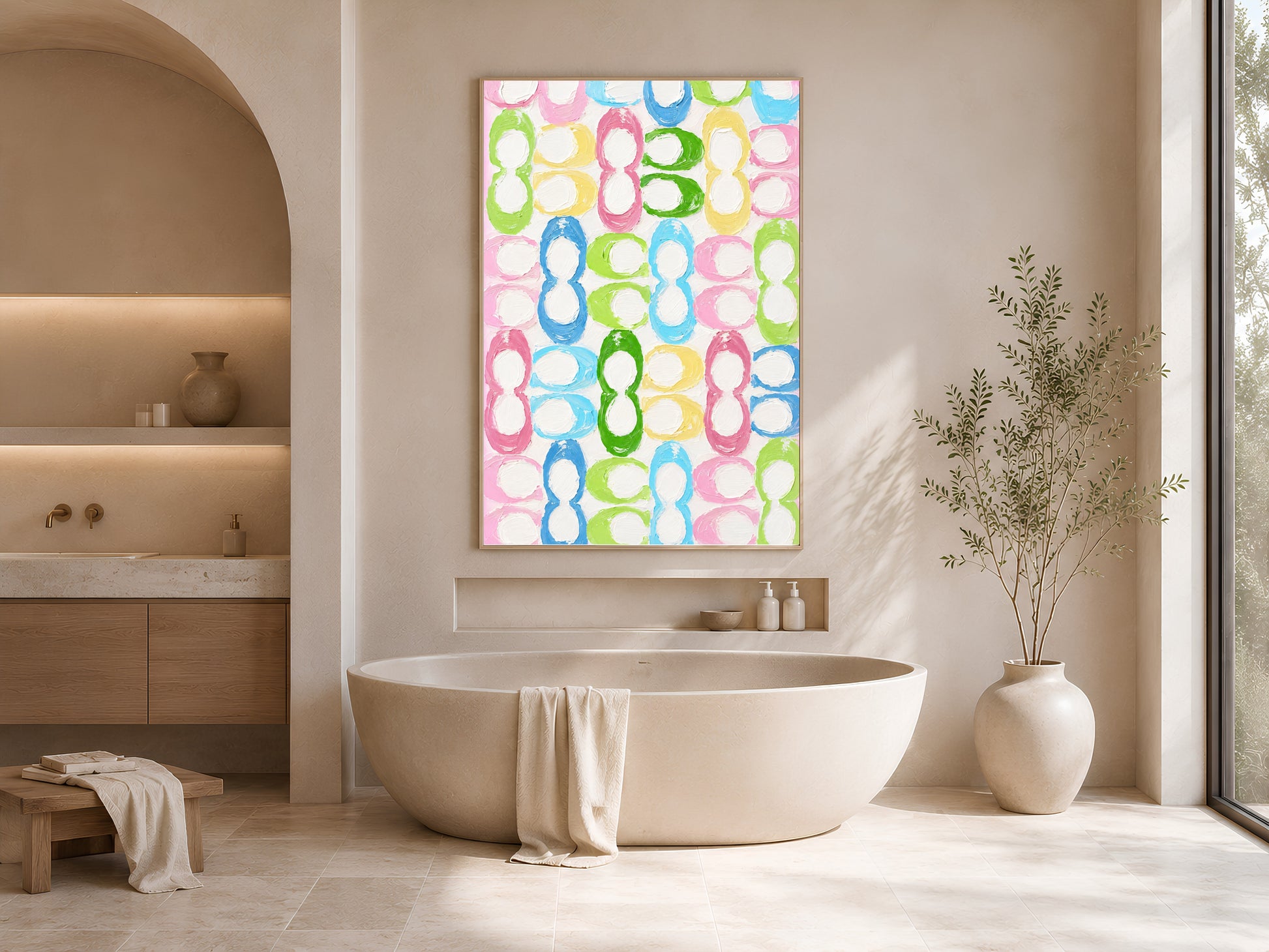 Colorful retro loop pattern print in gold frame beside freestanding bathtub in bright neutral bathroom with vase
