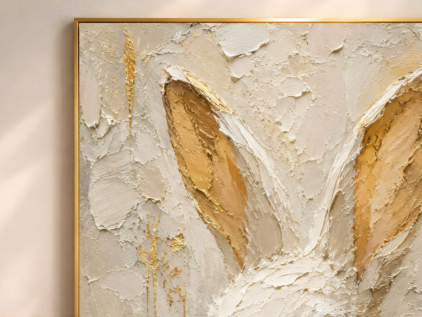 Close-up detail of white rabbit wall art in a gold frame showing thick impasto brushwork in cream, ivory, and warm gold leaf tones inside the rabbit's ears
