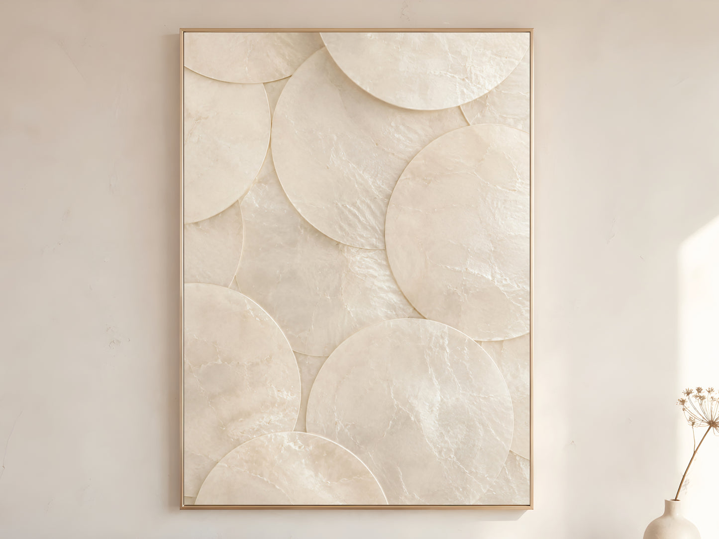Minimalist capiz shell disc wall art print in gold frame displayed on warm white living room wall showing large clean overlapping ivory shell circles with soft natural light and dried botanicals

