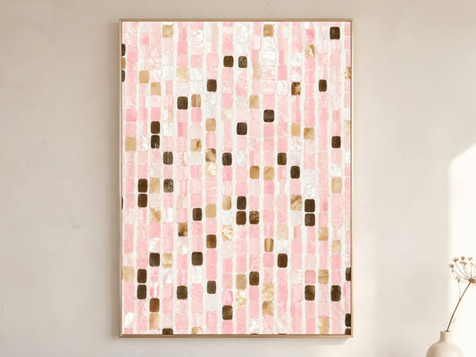 Pink mosaic tile wall art print in gold frame displayed on warm white living room wall showing blush pink pearl white champagne gold and espresso brown iridescent tile pattern with soft natural light
