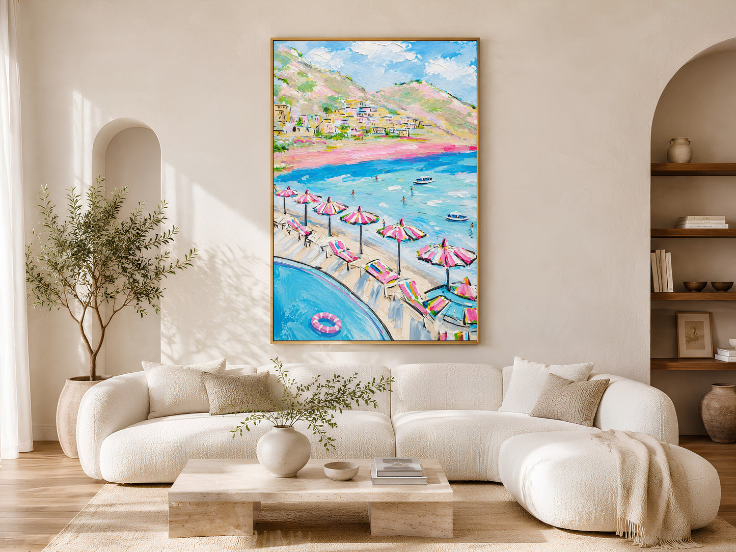 Positano Amalfi Coast impasto print in a wood frame styled above a cream curved sofa in a bright minimalist living room with warm wood floors and olive tree
