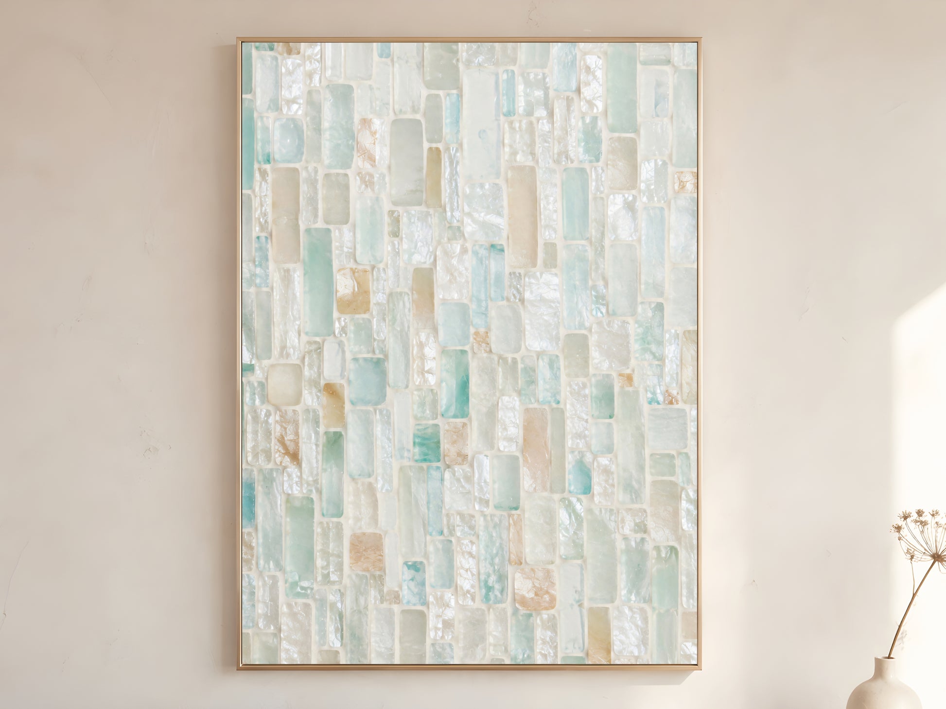 Sea glass mosaic tile wall art print in gold frame displayed on warm white living room wall showing soft aqua pale seafoam teal pearl white and warm sand rectangular brick tile pieces with dried botanicals
