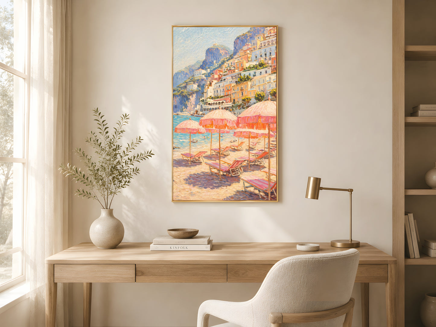 Positano beach club wall art in gold frame above wooden desk in bright Japandi home office with cream chair and warm natural light
