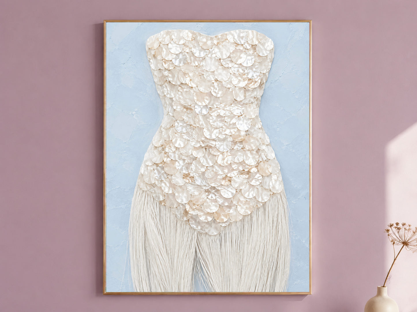 Mother of pearl wall art print in a thin gold frame with pale blue mat, displayed against a dusty mauve wall.