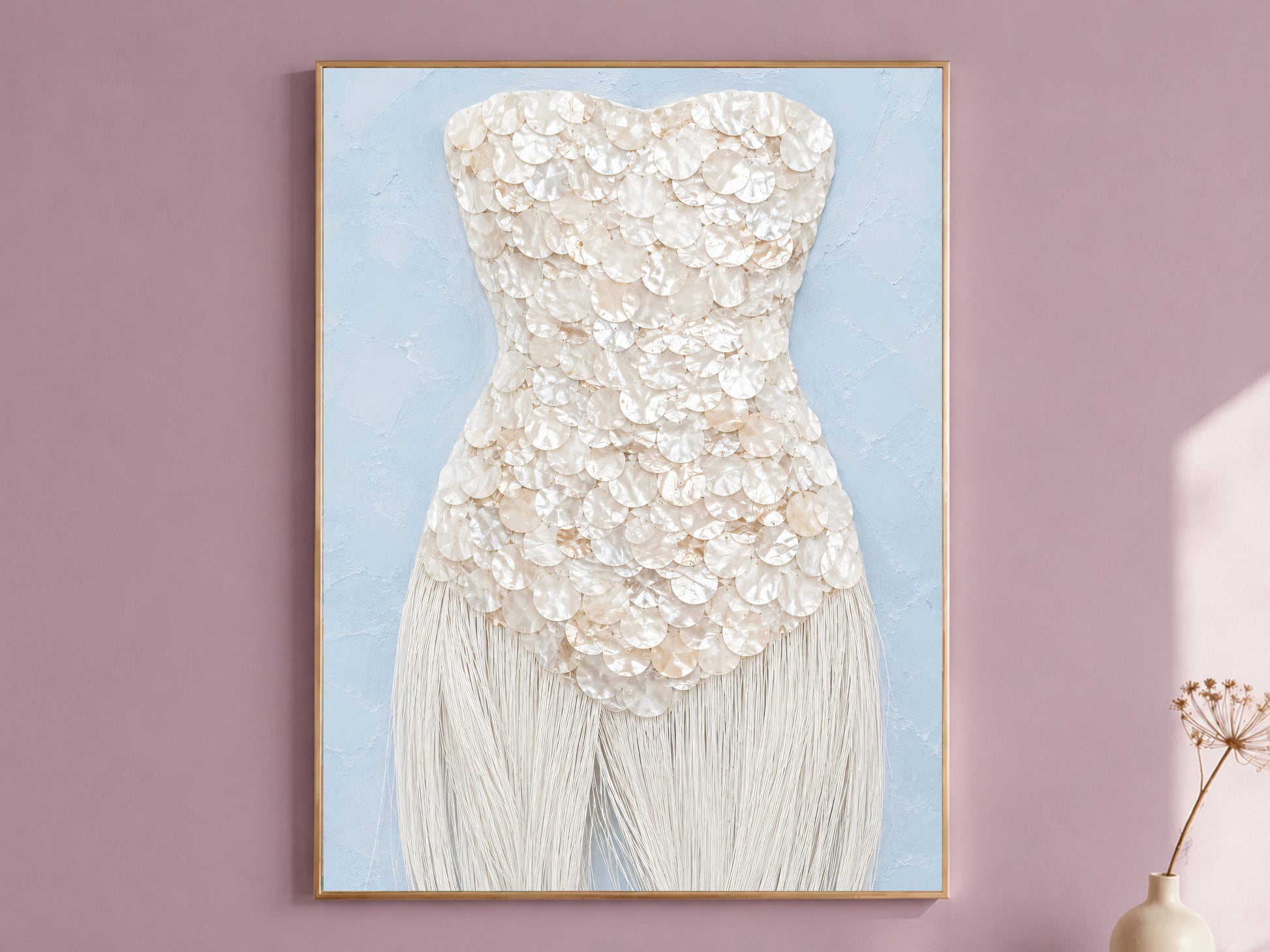 Mother of pearl wall art print in a thin gold frame with pale blue mat, displayed against a dusty mauve wall.
