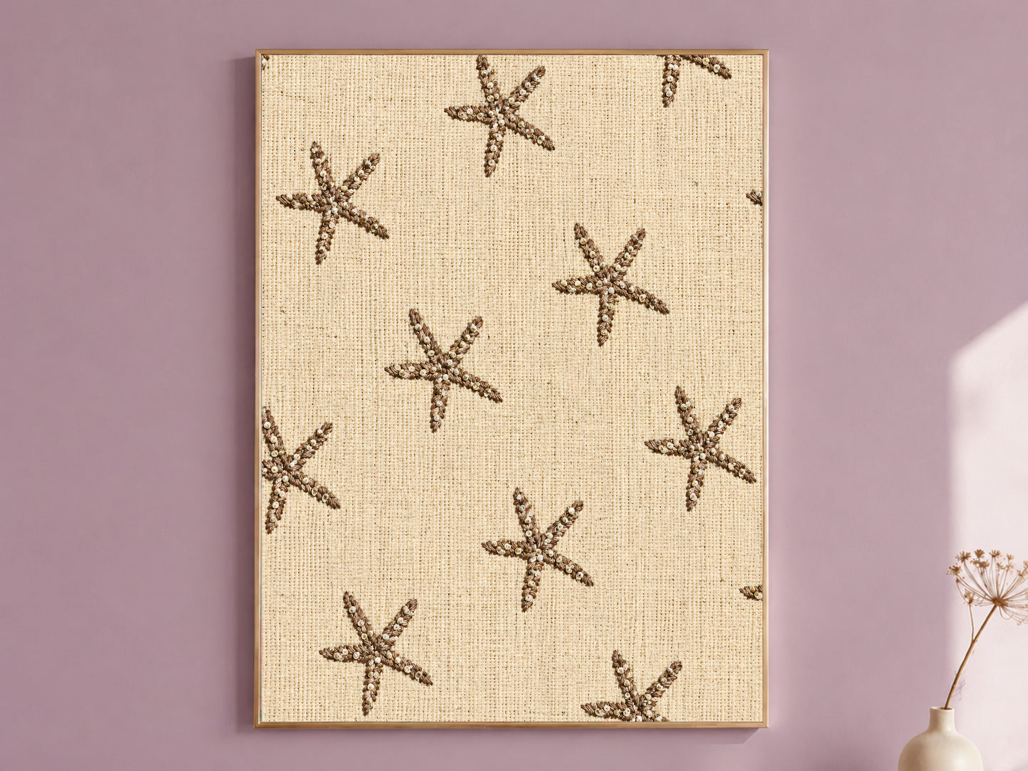 Framed embroidered starfish wall art on natural linen texture, styled on a dusty mauve wall