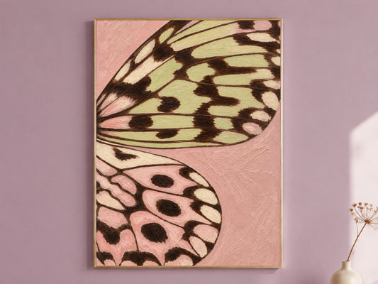 Framed butterfly wing wall art print in pink and sage green on a dusty mauve wall