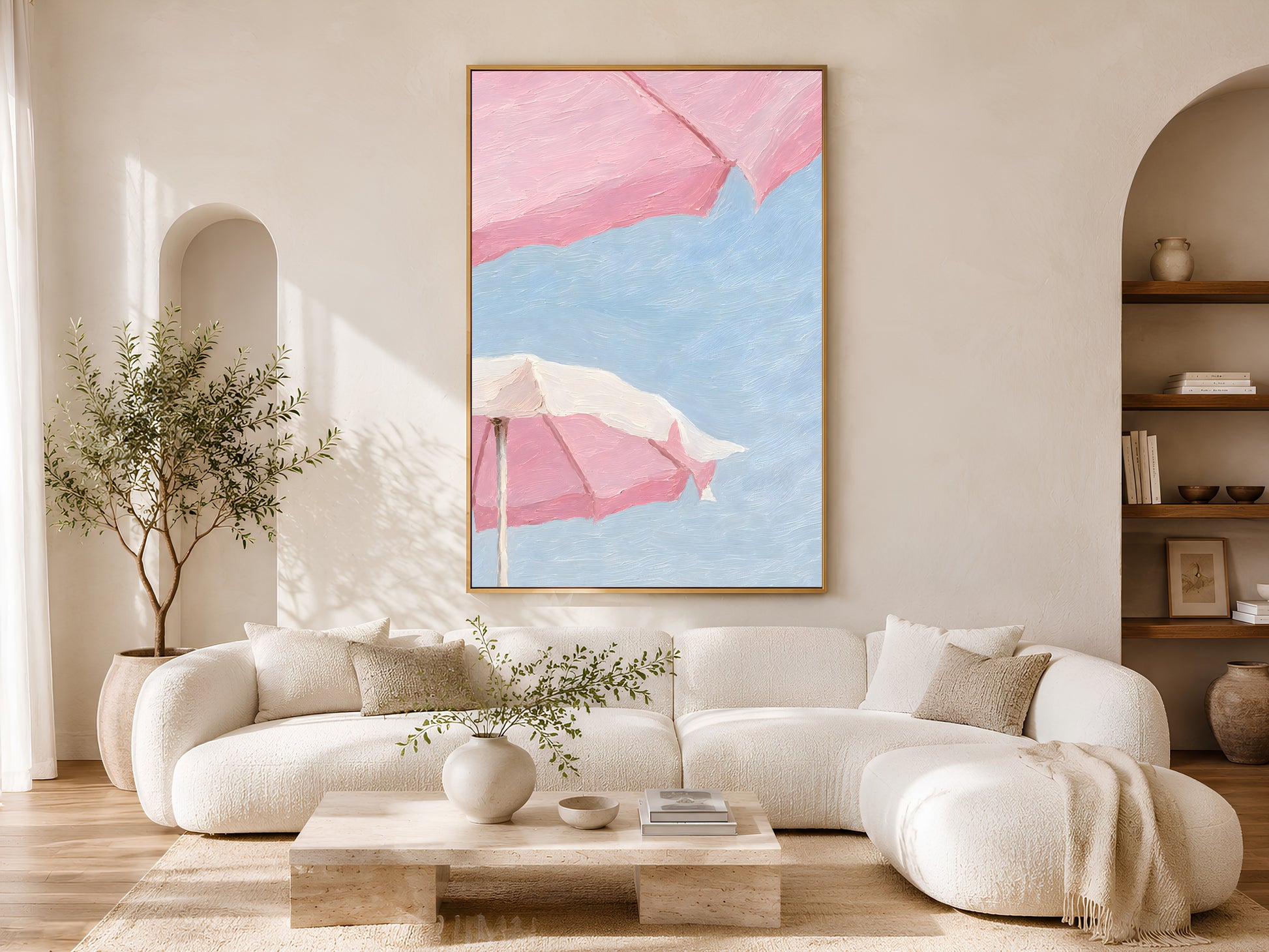 Pink beach umbrella wall art in a wood frame styled in a bright Scandinavian living room with cream curved sofa, warm wood floors, and olive tree
