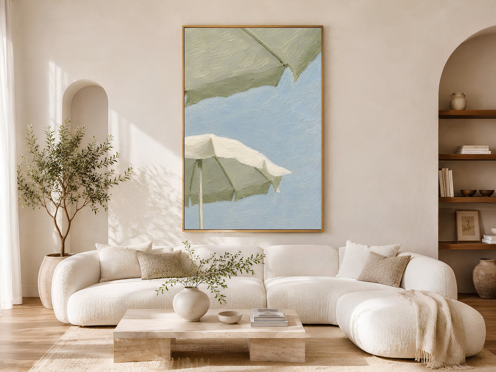 Sage green beach umbrella wall art in a wood frame styled in a bright Scandinavian living room with cream curved sofa, arched doorways, warm wood floors, and an olive tree
