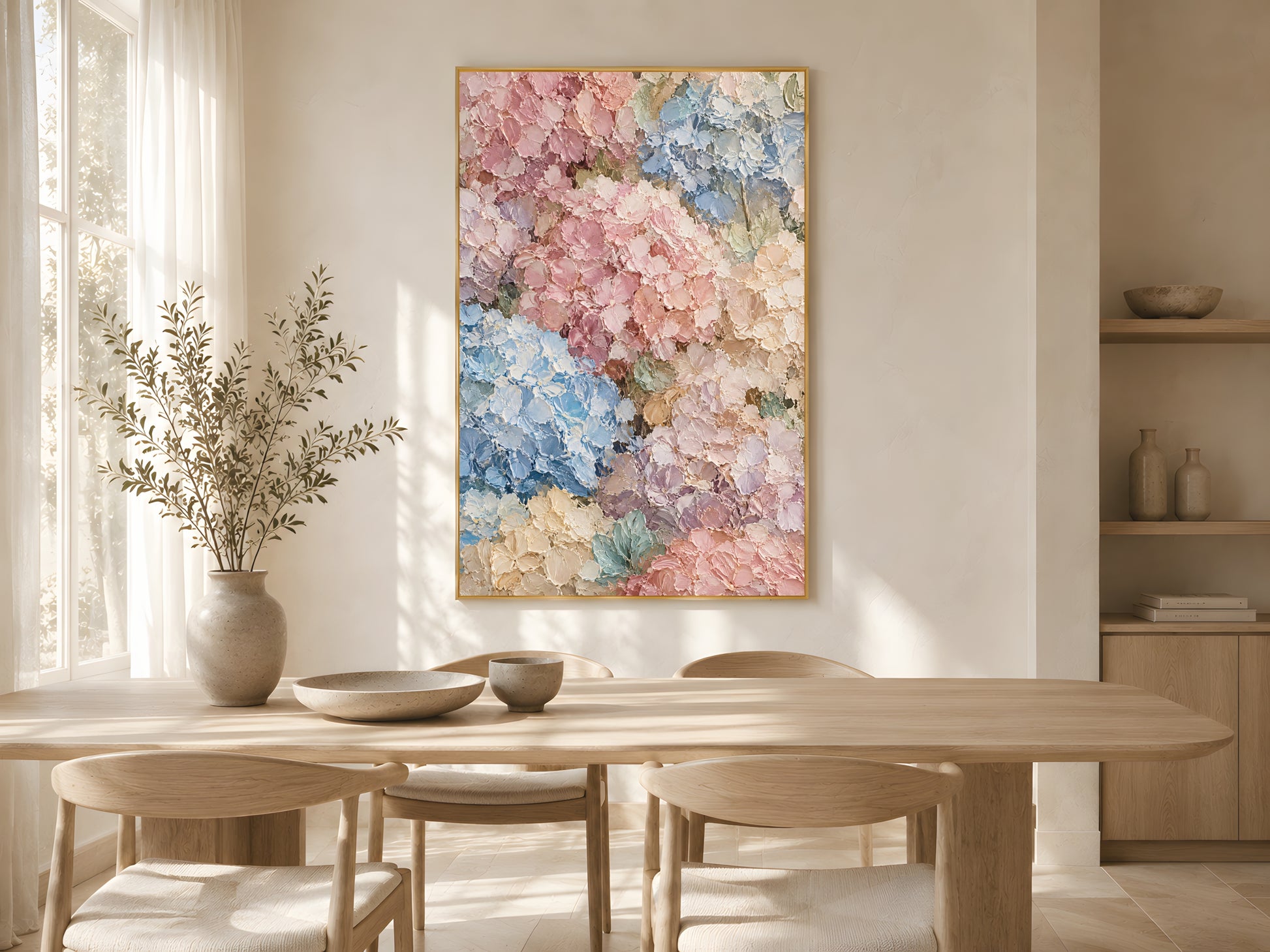 Pastel hydrangea impasto print in a gold frame above a light wood dining table in a bright Scandinavian dining room with dried stems
