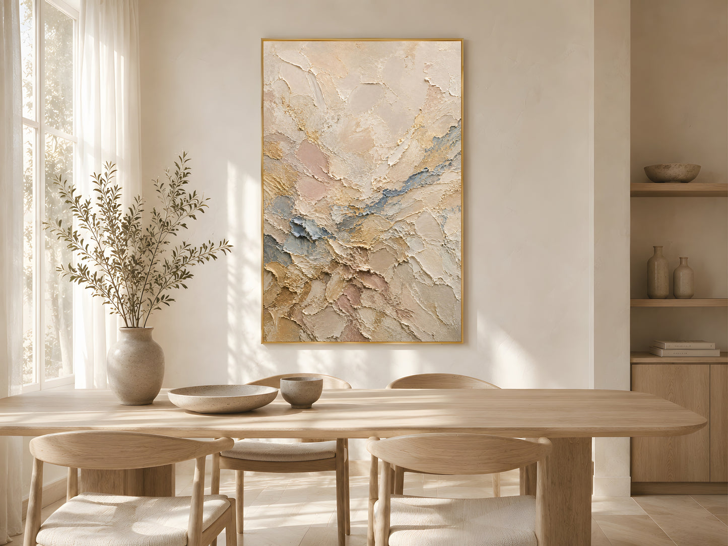 Neutral abstract impasto print in a gold frame above a light oak dining table in a warm minimal Scandinavian dining room with dried stems and natural light
