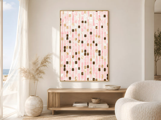 Pink mosaic tile print in gold frame beside sheer curtains in bright coastal living room with cream bouclé chair and dried pampas grass
