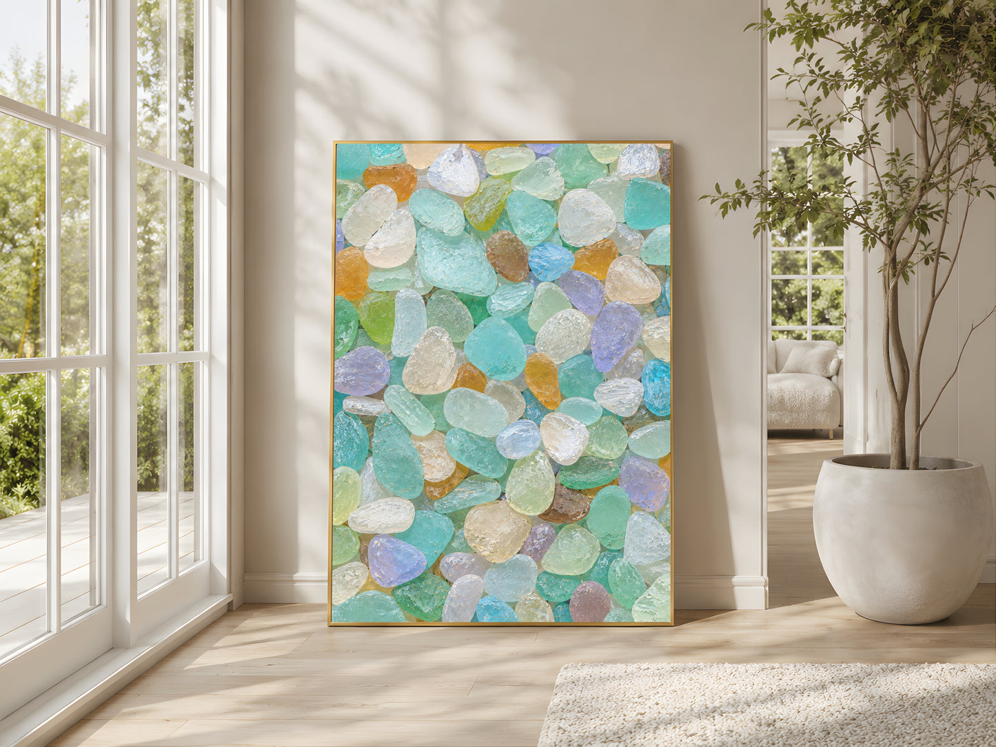 Colorful rainbow sea glass wall art in gold frame in bright coastal living room with large windows and indoor plants
