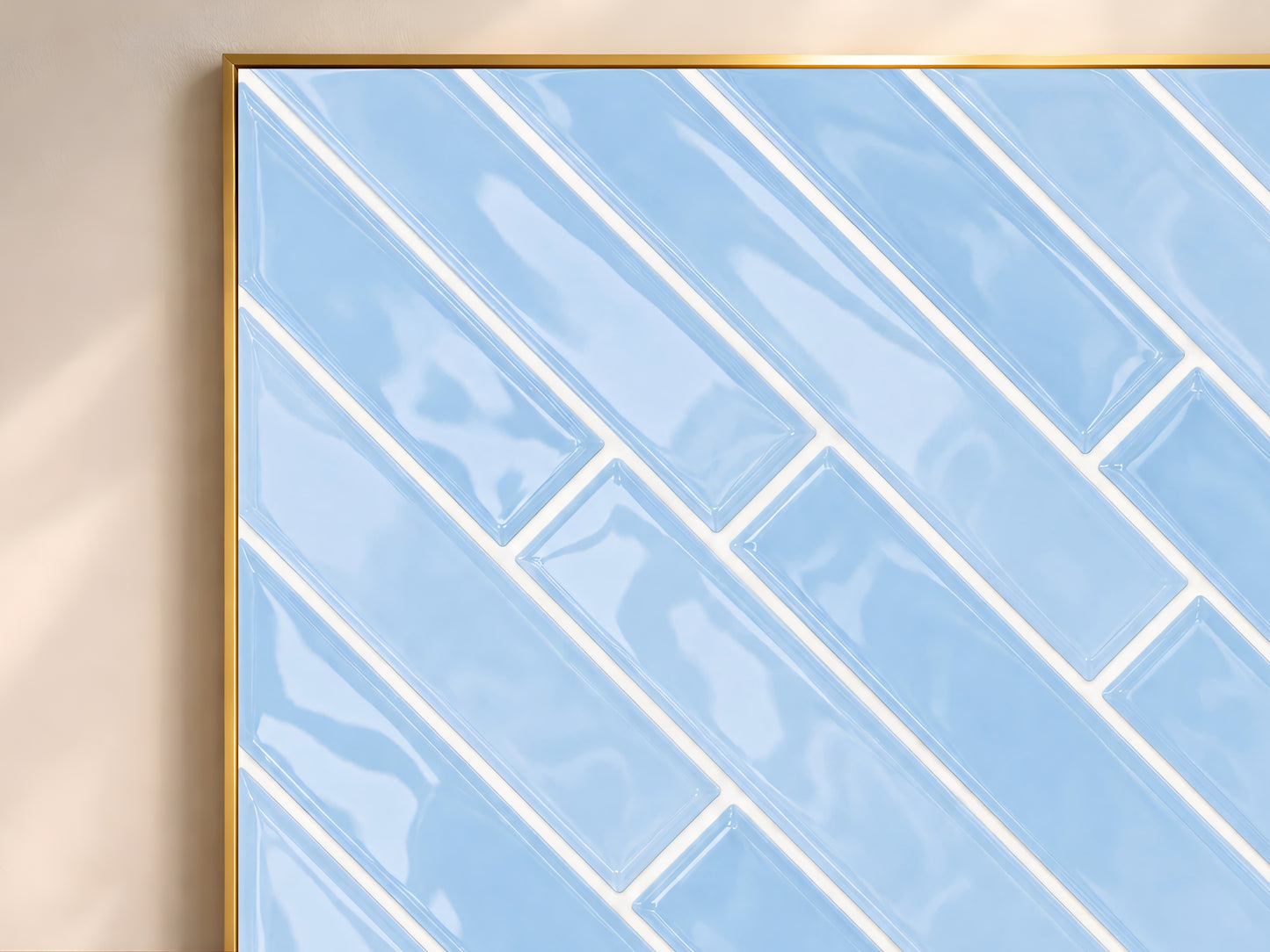 Close-up of the blue herringbone tile wall art print in a gold frame showing glossy powder blue ceramic tiles in a diagonal pattern with white grout lines
