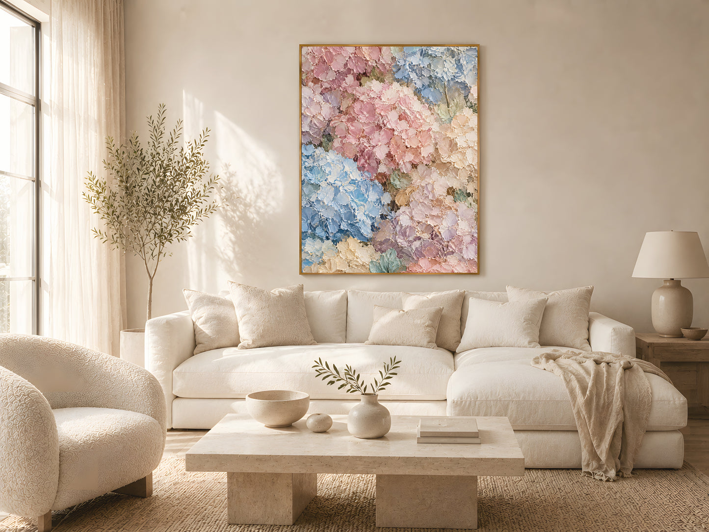 Pastel hydrangea wall art print in a gold frame above a cream linen sofa in a warm minimal living room with soft window light
