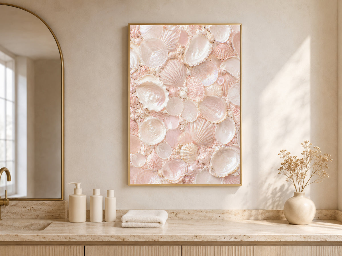 Framed blush pink shell mosaic art displayed above a bathroom vanity counter with candles