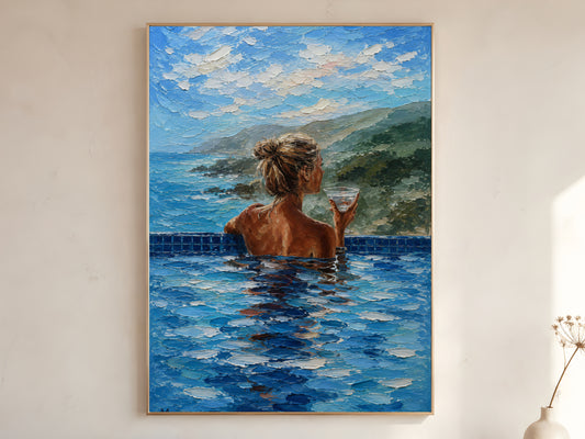 Woman in infinity pool with coastal mountain view impasto oil painting print in a thin natural wood frame, leaning against a warm white wall with a dried wildflower stem

