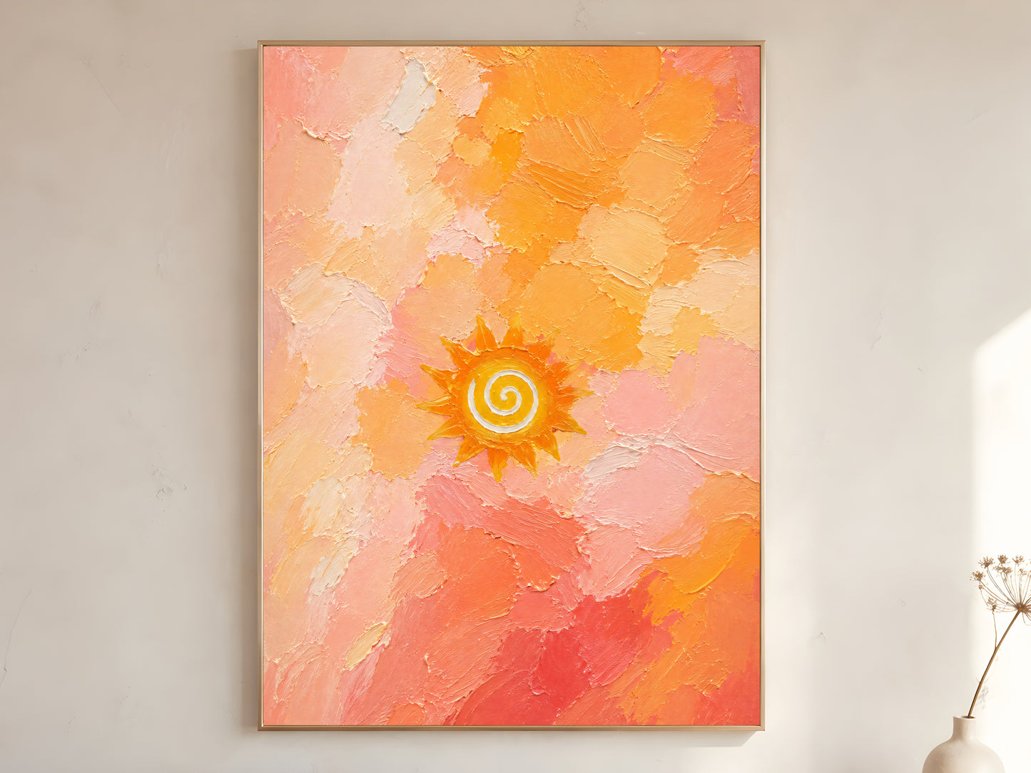 Boho sun spiral wall art print framed and hanging on a neutral wall with a vase and dried branches nearby.

