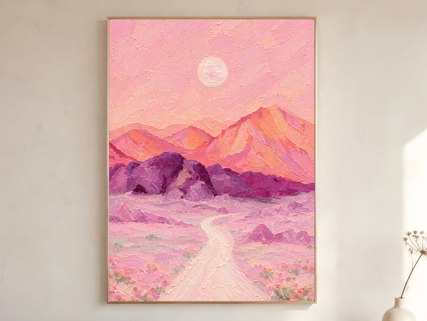 Surreal desert moon print framed above a bed in a warm neutral bedroom.