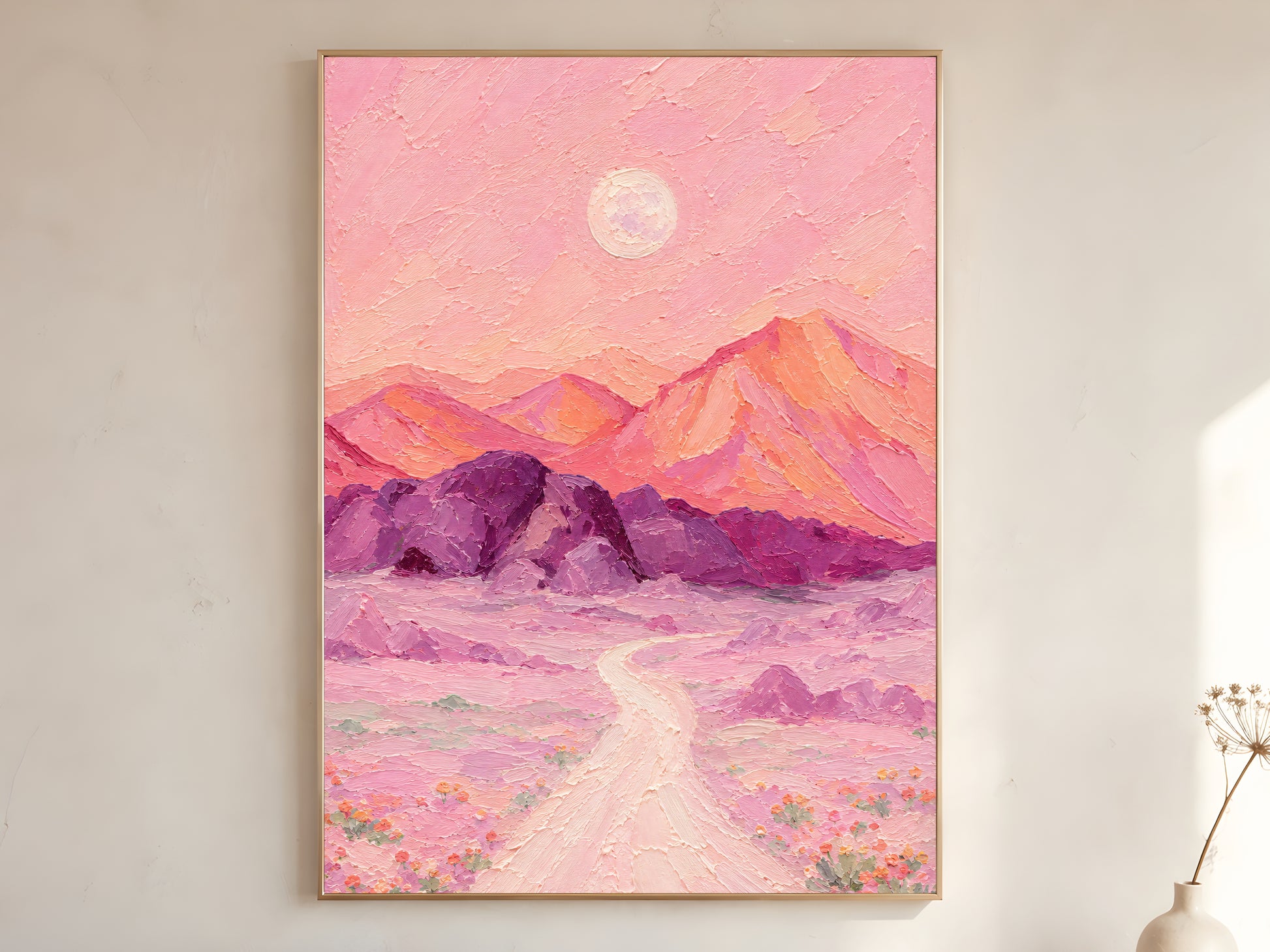 Surreal desert moon print framed above a bed in a warm neutral bedroom.