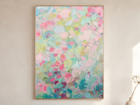 Pastel floral impasto wall art in gold frame on neutral wall beside dried flowers
