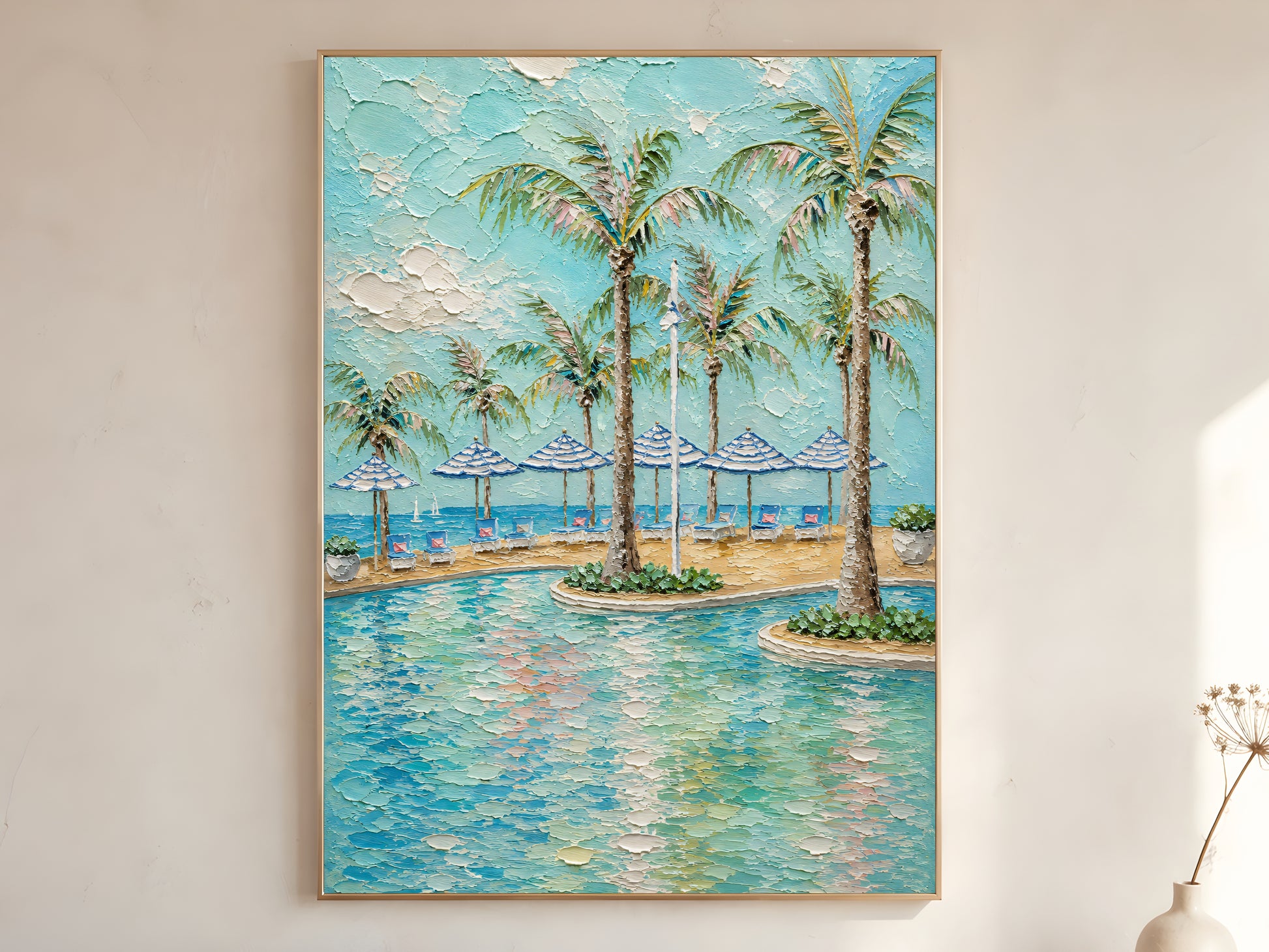 Tropical pool with palm trees and blue striped beach umbrellas impasto oil painting print in a thin natural wood frame, leaning against a warm white wall with a dried wildflower stem
