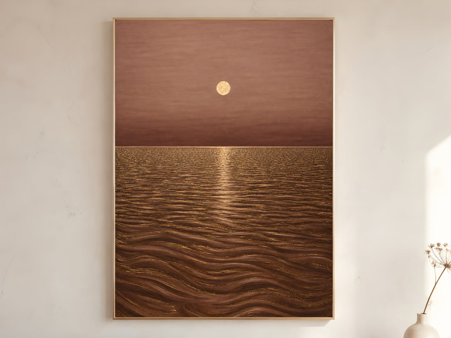 Golden moon ocean wall art in gold frame on neutral living room wall with vase
