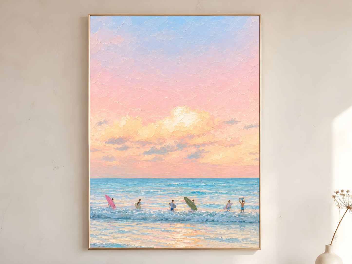 Large framed impasto pastel sunset surf wall art in gold frame leaning against white wall with dried botanicals in bright minimal room
