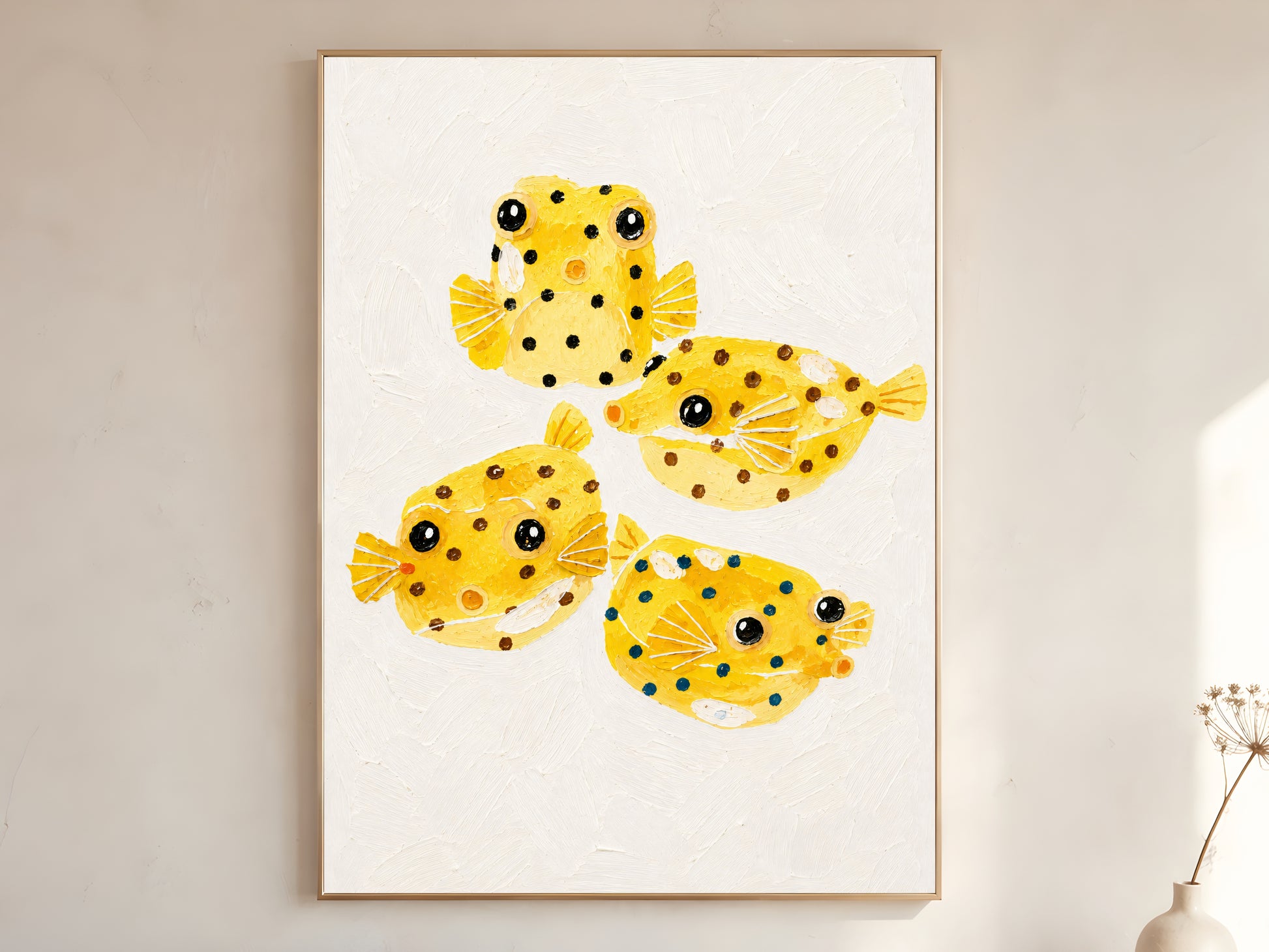 Framed impasto yellow boxfish wall art in gold frame on warm white wall with dried botanicals in bright minimal room
