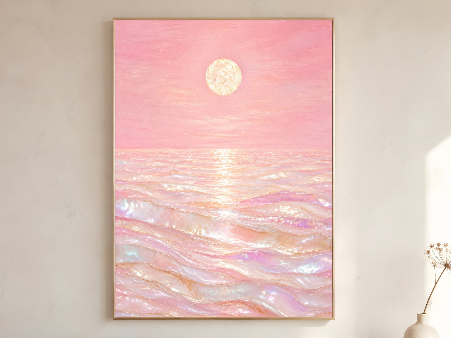 Pink capiz shell ocean wall art in gold frame on neutral wall beside dried flowers
